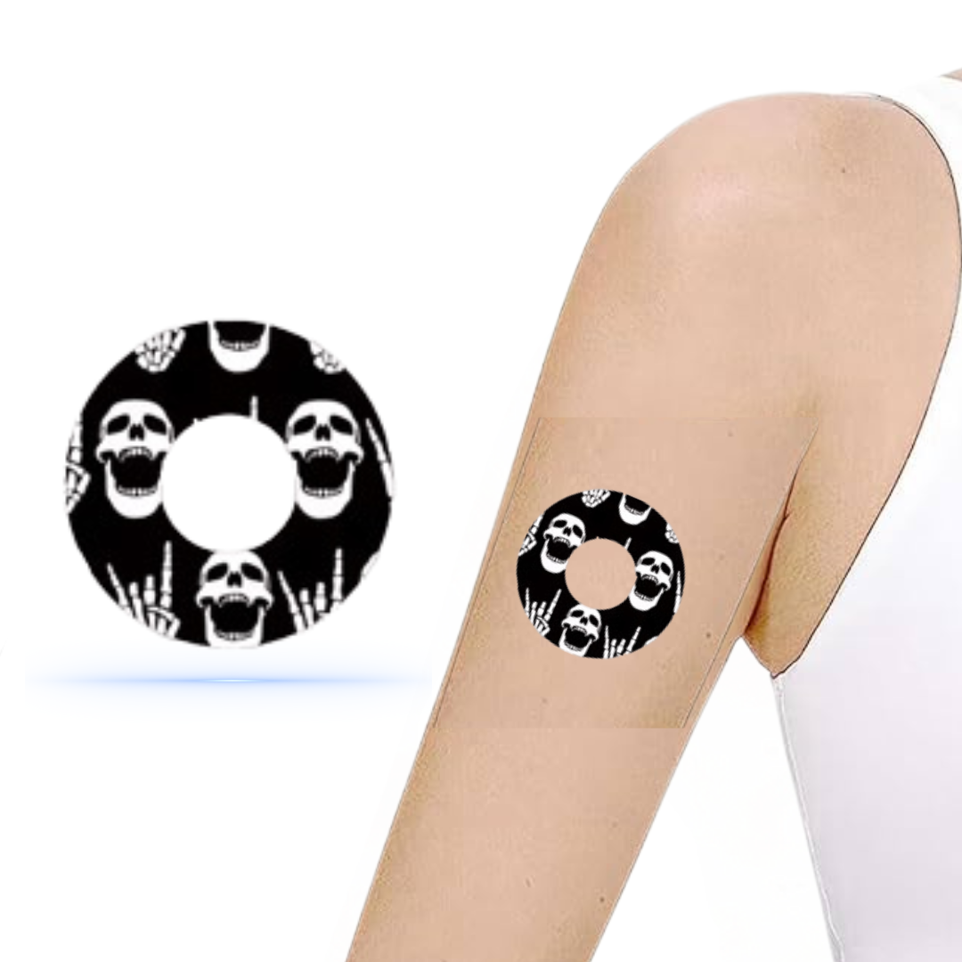 DiabetaGuard Rock'N'Roll Skull Sensor Patch på arm, visar stiligt dödskallemotiv och fingerskalle, perfekt för Freestyle Libre 3.