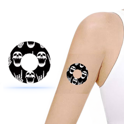 DiabetaGuard Rock'N'Roll Skull Sensor Patch på arm, visar stiligt dödskallemotiv och fingerskalle, perfekt för Freestyle Libre 3.