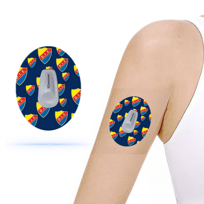 DiabetaGuard Djurgårdens IF CGM-patch för Dexcom G6 som appliceras på en arm, designad med klubbens logotyp på en blå bakgrund.