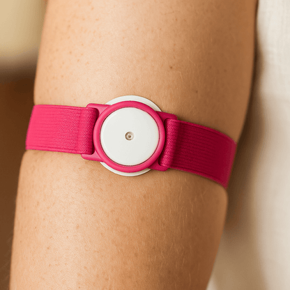 LibreLoop armband in pink securely holding a Freestyle Libre sensor on arm.